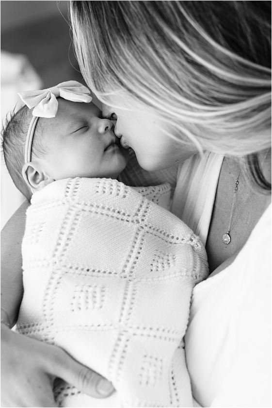 mom kissing newborn
